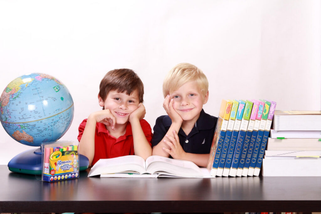 Niños estudiando con libros en un entorno educativo que representa el aprendizaje y la educación digital